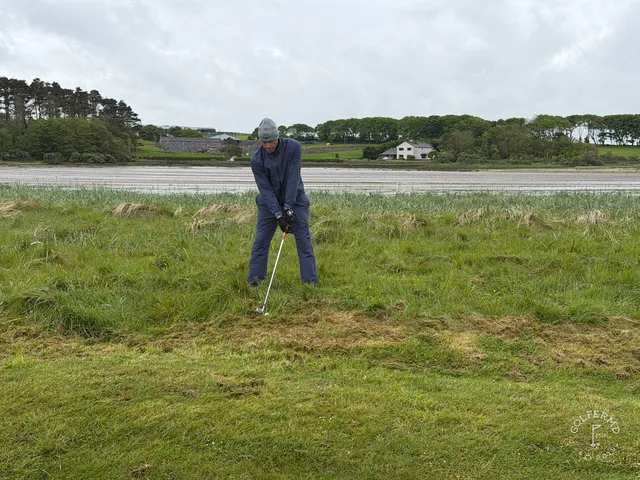 A green and flagstick at Enniscrone above the water, with a bunker short of the green.