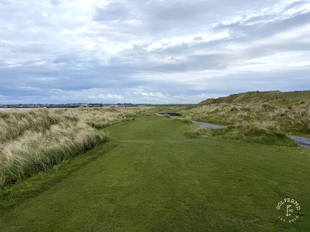 A fairway at Enniscrone with a bunker along one side and the water ahead.