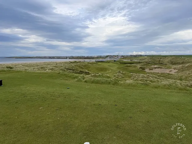 A wide view across Enniscrone, with fairway, dunes, and the water.