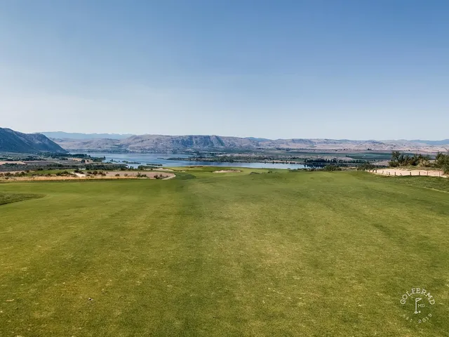 A fairway at Gamble Sands from above, sandy waste along the left and the green set toward the mountains.