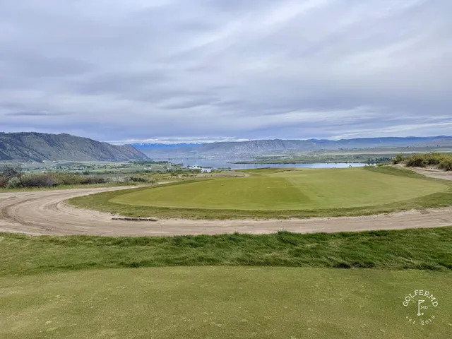 A green and flagstick at Gamble Sands, a sandy bunker on the front right and the fairway behind.