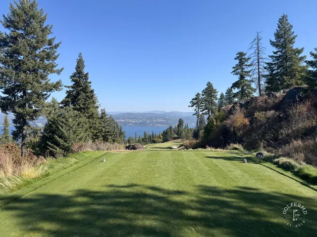 Another view of a fairway at Gozzer Ranch, with pine trees and the lake in the distance.