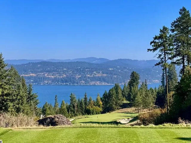 A third view of a hole at Gozzer Ranch, with pines, the lake, and mountains.