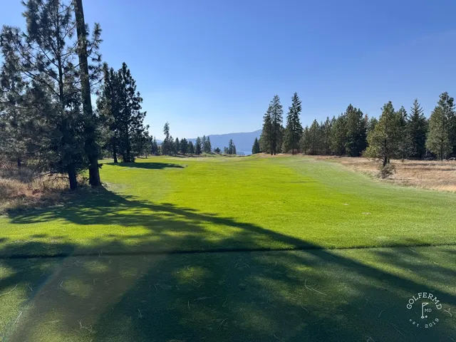 A fairway and green at Gozzer Ranch, with a bunker in the foreground and the lake beyond.