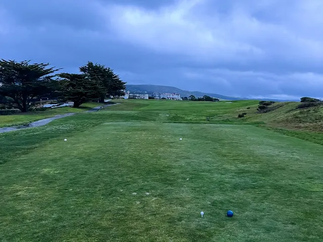 A Ritz-Carlton scorecard and a Half Moon Bay yardage book open on a table.