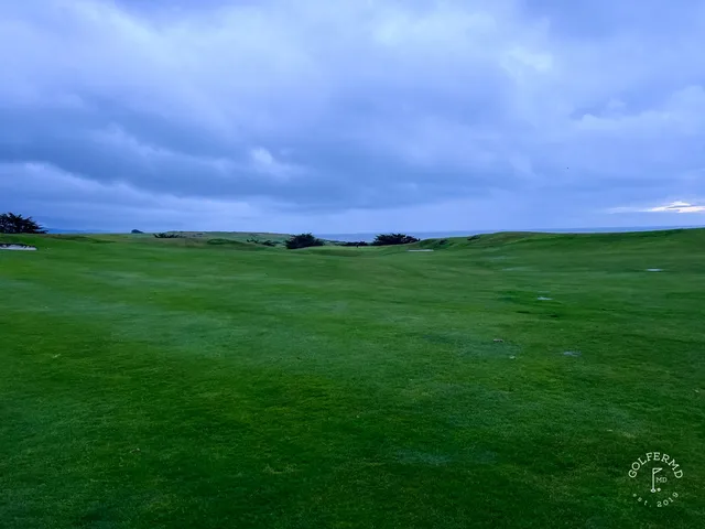 A green and flagstick above the ocean at Half Moon Bay Golf Links Ocean Course, with the cliffs along the coast.