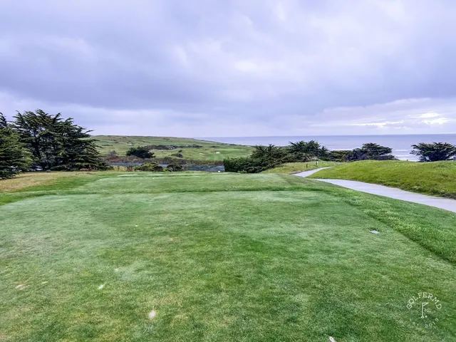 A green and flagstick above the ocean at Half Moon Bay Golf Links Ocean Course.