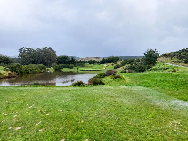 A green and flagstick above the ocean at Half Moon Bay Golf Links Ocean Course, with the cliffs along the coast.