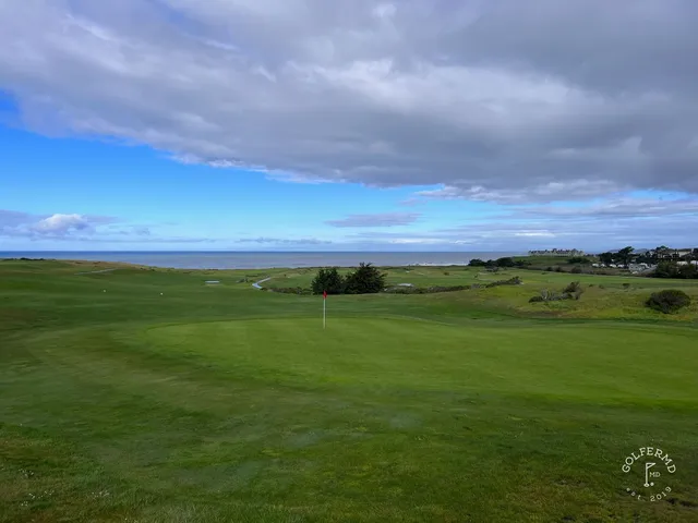 A fairway leading toward the ocean at Half Moon Bay Golf Links Ocean Course, with cypress trees along the hole.