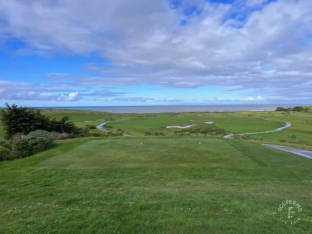 A green and flagstick above the ocean at Half Moon Bay Golf Links Ocean Course.