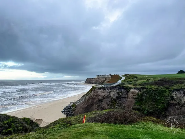 A green and flagstick above the ocean at Half Moon Bay Golf Links Ocean Course, with the cliffs along the coast.