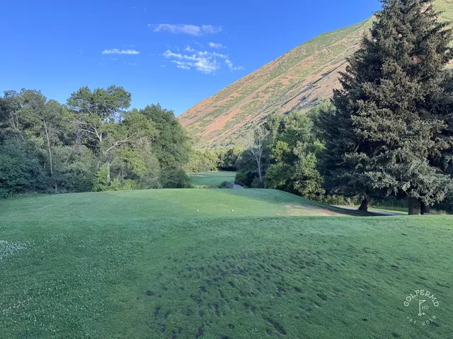 A tee view at Hobble Creek, a bunker on the right of the fairway and the green toward the mountains.