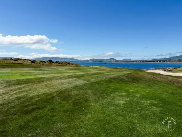 A golfer putting on a green at Hogs Head, with the ocean beyond the hole.