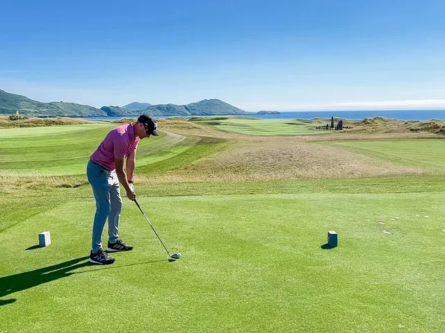 A fairway and green at Hogs Head, with a bunker in the foreground and the bay beyond.