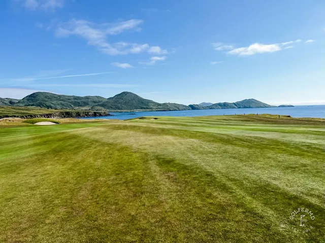 A green and flagstick at Hogs Head, seen from a rise, with the Atlantic behind the hole.