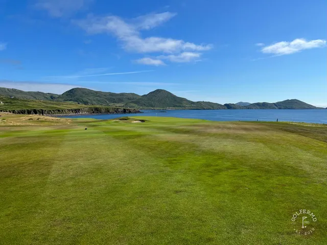 A green and flagstick at Hogs Head, seen from the tee, with the ocean behind the hole.