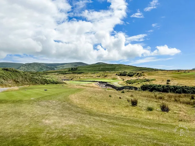 A fairway at Hogs Head lined with beach grass, with the ocean in the distance.