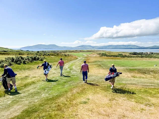 A group of golfers at Hogs Head, with the course and the bay behind them.