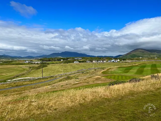 A golfer hitting a shot at Hogs Head, with the sandy fairway and the ocean ahead.
