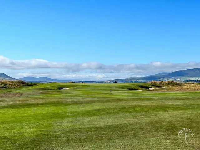 A golfer hitting a shot at Hogs Head, with the fairway stretching toward the Atlantic.
