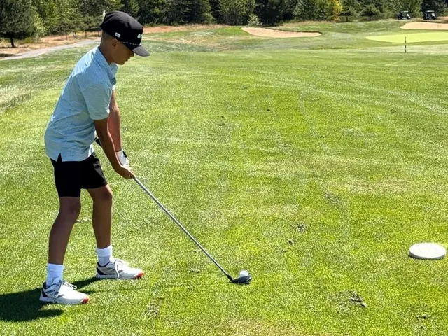 A wide fairway at The Home Course, with evergreens along the edges.