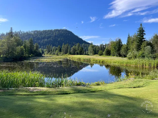 A wide fairway at The Idaho Club, with mountains and the lake in the distance.