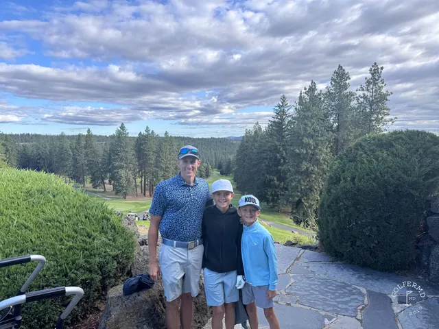 A fairway at Indian Canyon, with pines and the Spokane hills beyond.
