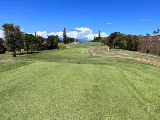 A wide hole at the Kai Course, with sand bunkers and the ocean along the right side.