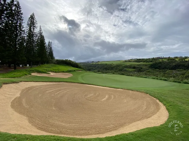 A fairway and green at the Plantation Course, with mountains in the distance.