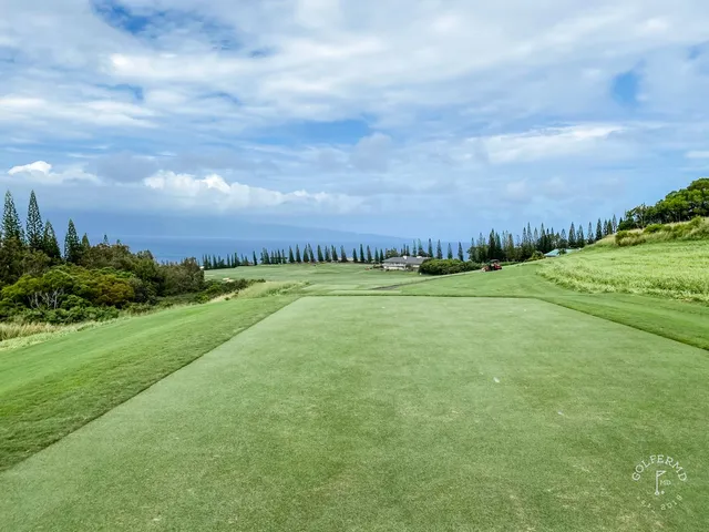 A green and flagstick at the Plantation Course, with the Pacific behind the hole.