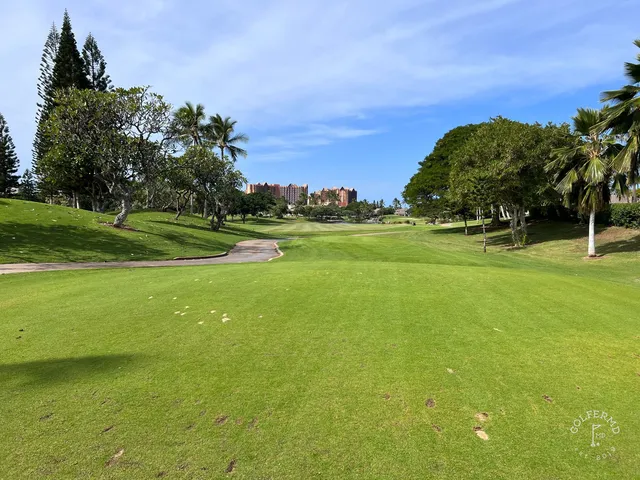 A fairway and green at Ko Olina, with a sand bunker beside the green and palm trees around the hole.