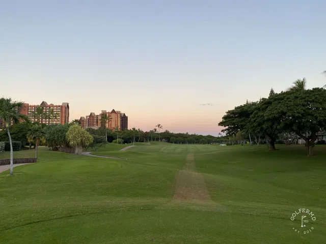 A close view of a green and flagstick at Ko Olina, with the ocean behind the hole.