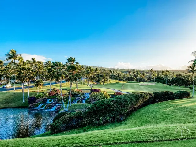 A wide view at Ko Olina, with a fairway, sand bunkers, and the ocean on the horizon.