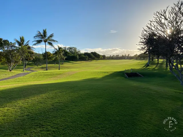 A fairway at Ko Olina with a sand bunker in the foreground and palm trees along the right.