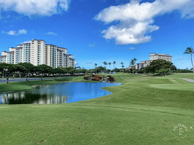 A group of golfers on a green at Ko Olina, with the ocean behind them.