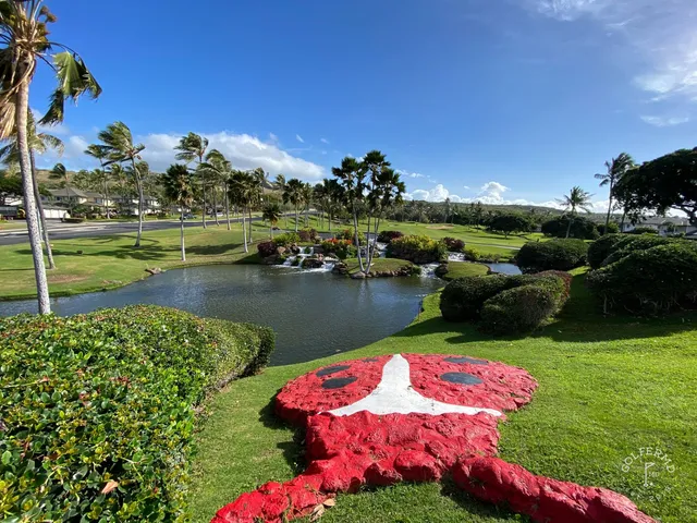 A wide view of Ko Olina, with a pond, palm trees, and the Pacific on the horizon.