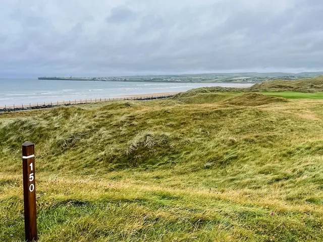 A fairway at Lahinch lined with dunes, running toward the water.