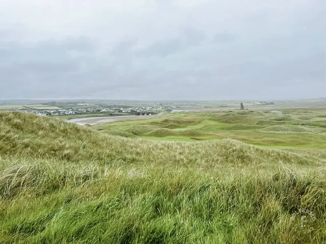 A fairway at Lahinch bending through the dunes toward the beach.