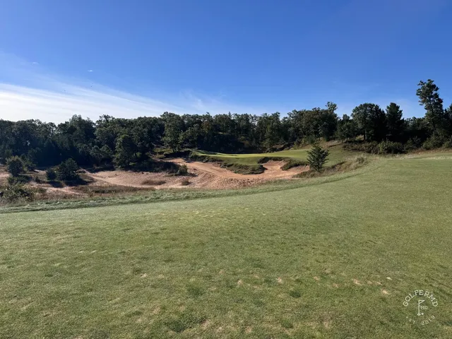 A green and flagstick at Mammoth Dunes, seen from the fairway, with bunkers around the hole.