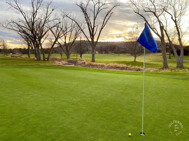 A golfer hitting a shot at Meadow Springs, with the fairway ahead.