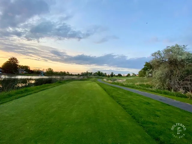 A green and flagstick at Meadow Springs, seen from a rise.