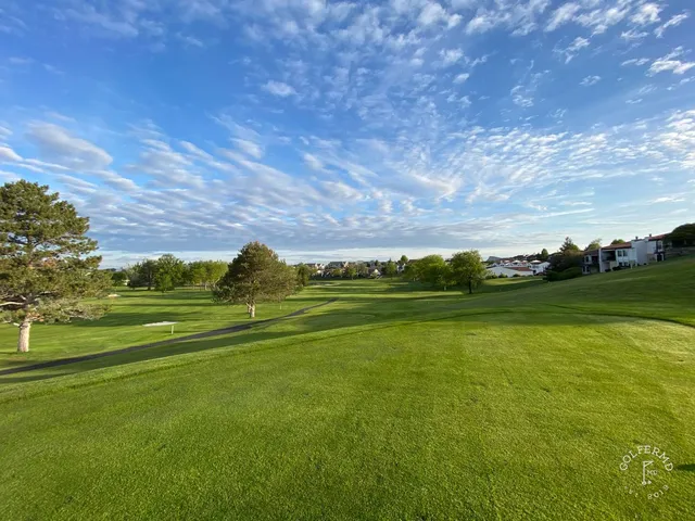 A green and flagstick at Meadow Springs, with a bunker in front and the hills beyond.