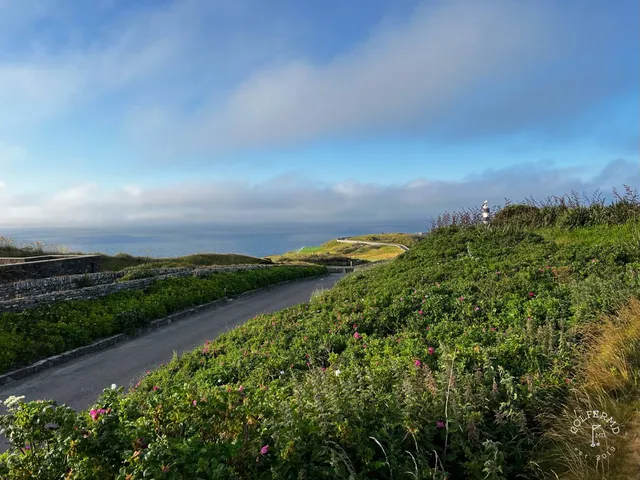 A wide view from the cliffs at Old Head, with the lighthouse and the water.