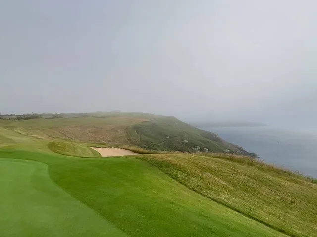 A green and flagstick at Old Head perched above the cliffs.