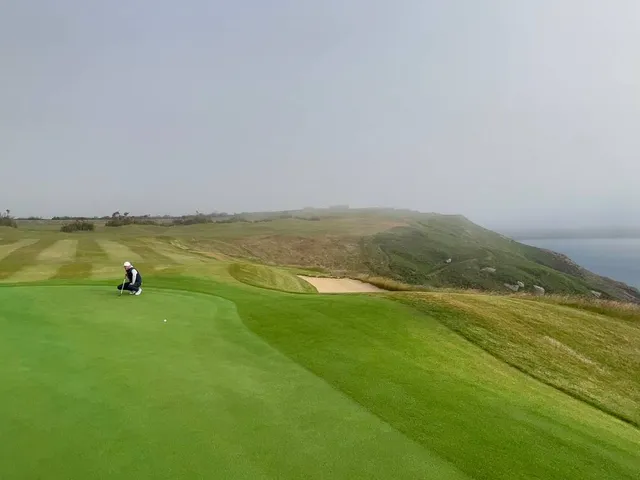Golfers on a tee at Old Head, with the ocean behind them.