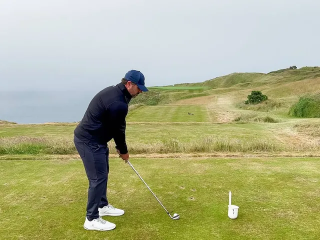 A close view of a flagstick at Old Head, with the ocean below the green.