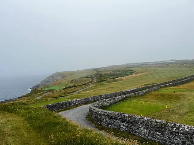The cliffs and the lighthouse from a hole at Old Head.