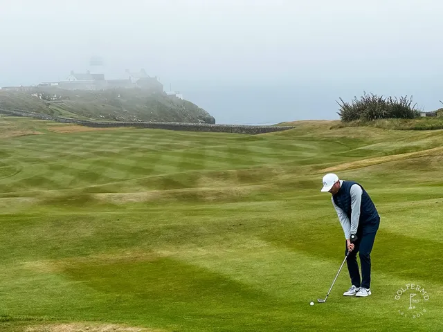 A fairway and green at Old Head, with a bunker in the foreground and the ocean beyond.