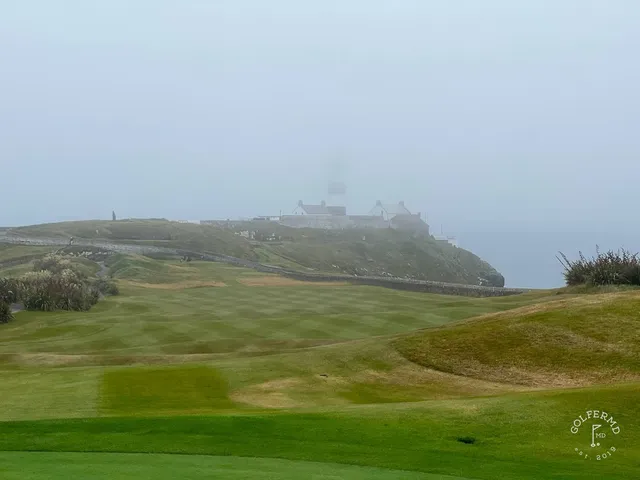 A wide view of Old Head, with the fairway and the Atlantic.