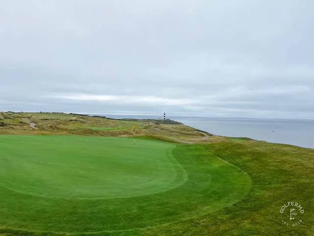 A golfer putting on a green at Old Head, with the Atlantic beyond.